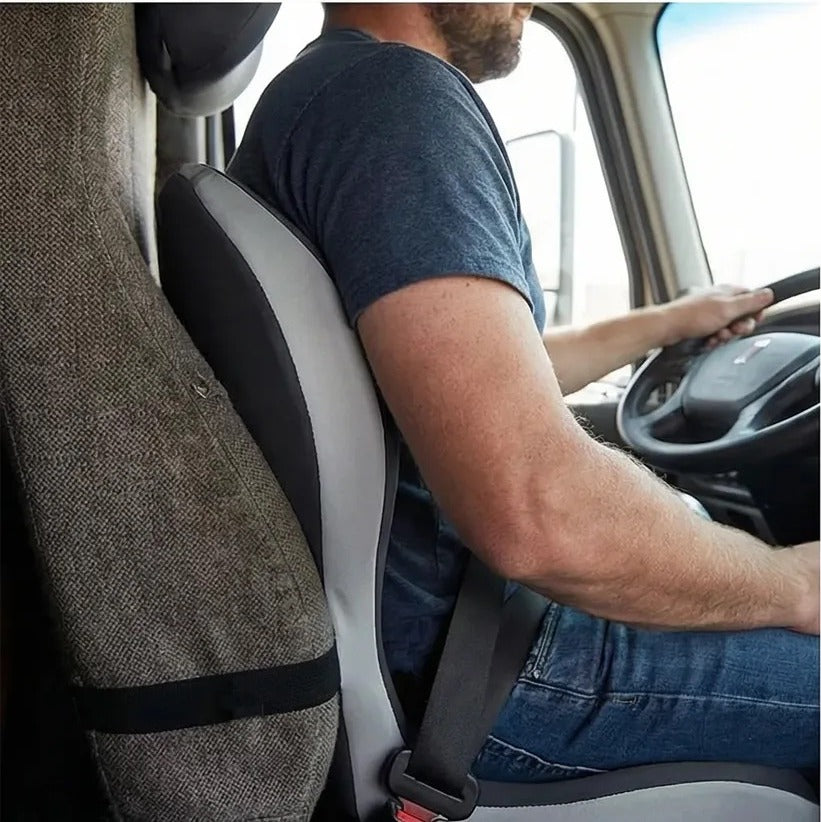 A driver at the wheel with the cushion behind his lower back